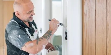 Tradesman painting a door frame as part of an interior decorating service